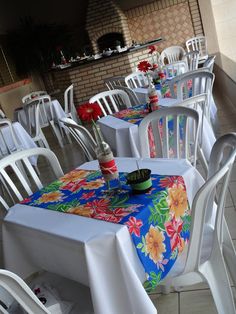 there are many tables with white chairs at this restaurant