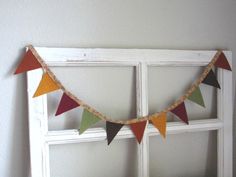 an old window frame is decorated with multicolored pennants