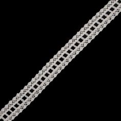 a white crochet bracelet on a black background