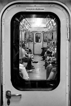 people are sitting on the subway train and looking out the window at the other side