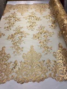 a white and gold table cloth on top of a wooden table