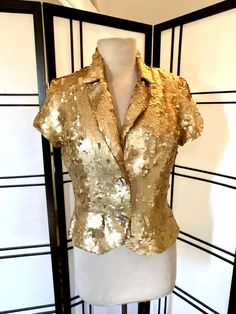 Vintage gold sequin jacket, cropped sequin jacket by Twelfth Street NWT. Please zoom in for details, photos are part of description. This flashy gold sequin top has elastic cap sleeves, two faux front pockets and shell buttons for closure. Label states 100% silk size medium, please go by measurements provided. In very good condition, no holes or stains. Measurements taken with garment lying flat  Shoulder: 15" Bust: 19" underarm to underarm ( 38" doubled ) Waist: 15" seam to seam ( 30" doubled ) Gold Sequined Outerwear For Spring, Fitted Sequin Outerwear For Holidays, Embellished Gold Outerwear For Spring, Spring Embellished Gold Outerwear, Gold Embellished Outerwear For Spring, Fitted Gold Outerwear For Holiday, Festive Fitted Gold Outerwear, Gold Outerwear For Night Out And Party Season, Gold Outerwear For Party Season Night Out