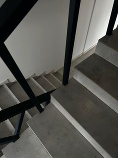 the stairs are made of concrete and have black metal handrails