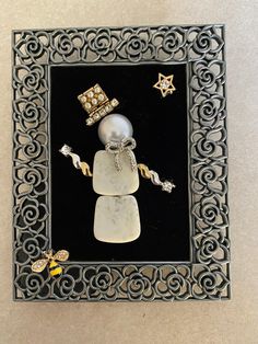 a black and white frame with an image of a snowman wearing a hat, holding a star