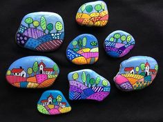 painted rocks with houses and trees on them