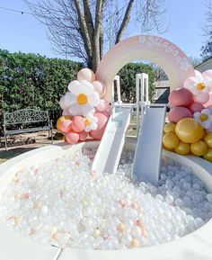 an inflatable ball pit with flowers and balloons