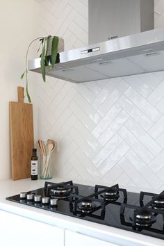 a stove top oven sitting inside of a kitchen next to a cutting board and knife