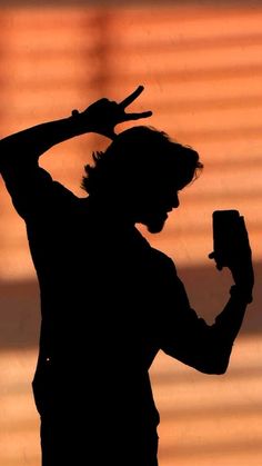 the silhouette of a man holding a cell phone