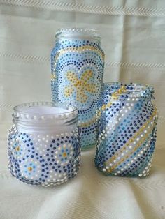 three blue and white glass jars sitting next to each other on top of a table