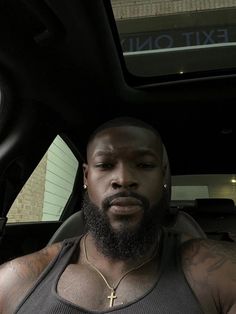 a man with a beard sitting in the back seat of a car