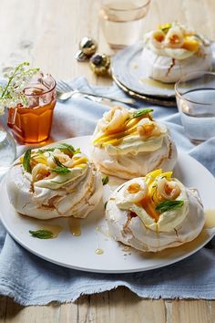 some food is on a white plate with silverware and glass cups in the background