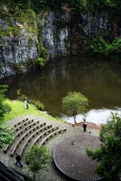 an aerial view of a small lake with steps leading up to it and people standing in the water