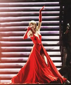 taylor swift performing on stage in a red dress