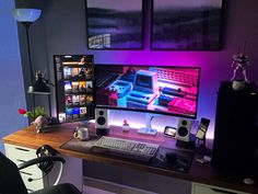 a computer desk with two monitors, keyboard and mouse on it in front of purple lighting