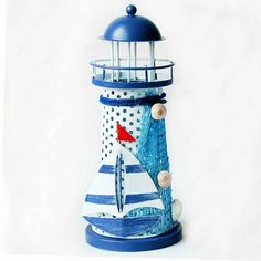 a blue and white lighthouse with a red fish on it's side, sitting in front of a white background