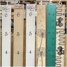 three different wooden rulers are shown with numbers on them and one has a dandelion