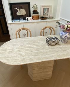 a table with chairs and vases on it in the middle of a living room