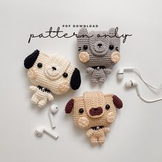 three crocheted dogs with earbuds on top of a white table next to each other