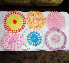 crocheted doily laid out on top of a white cloth with different colors