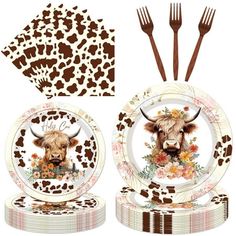 a set of plates and utensils with an image of a cow on them