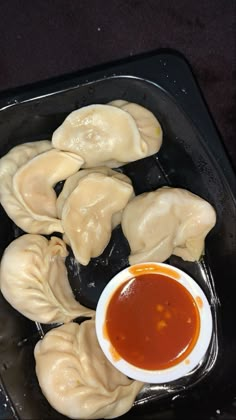 dumplings with dipping sauce in a plastic container