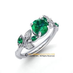 an emerald and diamond ring with leaves on the side, set in white gold or silver