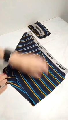 a person is cutting fabric with scissors on a table