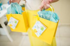 a woman holding two yellow bags with tags on them