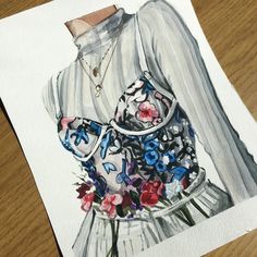 a drawing of a woman's dress with flowers on the front and back, sitting on a wooden surface