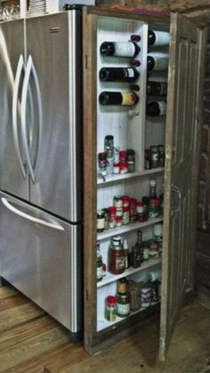 an open refrigerator in a kitchen with lots of bottles and cans on the door shelf