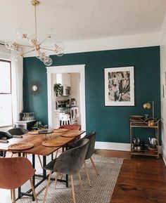 a dining room with green walls and wooden floors