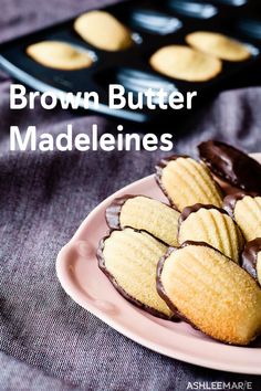 chocolate dipped cookies on a plate with the words brown butter madeleines in front of them