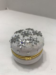 a white box with some silver and gold decorations on top of it's lid