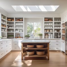 a kitchen filled with lots of white cabinets and counter top space next to a window