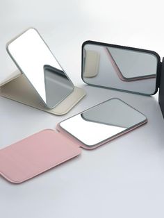 three mirrors with different shapes and colors on them, one is pink, the other is white