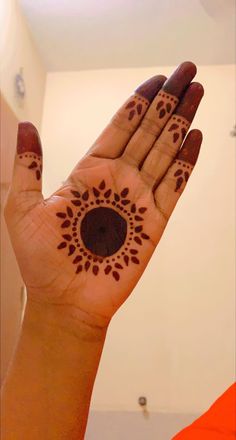 a woman's hand with henna tattoos on it