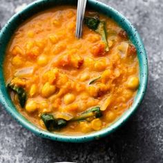 two bowls of soup with spoons in them