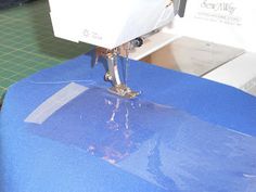 the sewing machine is being used to sew something on it's blue table