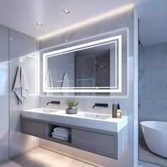 a bathroom with a sink, mirror and bathtub in the middle is illuminated by lights