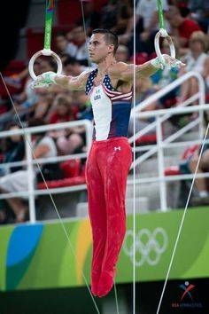 a man is performing on rings in front of an audience