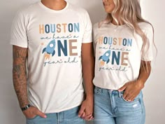 two people standing next to each other wearing shirts with the words houston and one planet printed on them