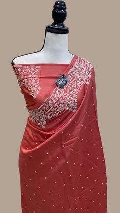 a mannequin wearing a red sari with white and silver designs on it