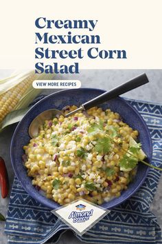 a bowl filled with corn on top of a blue towel next to a red pepper