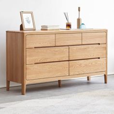 a wooden dresser sitting on top of a carpeted floor next to a white wall