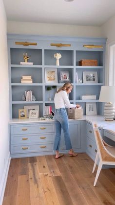 a woman standing in front of a blue bookcase