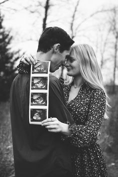 black and white photograph of a couple embracing each other with pictures in front of them