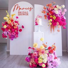 the flowers are hanging on the wall in front of the bride's shower sign