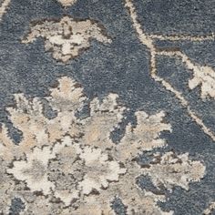 a blue rug with an ornate design on the top and bottom, is shown in close up