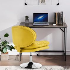 a yellow chair sitting in front of a desk with a laptop computer on top of it