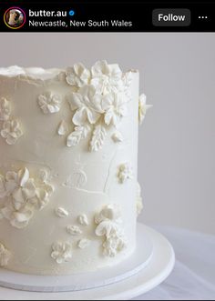 a white wedding cake with flowers on it